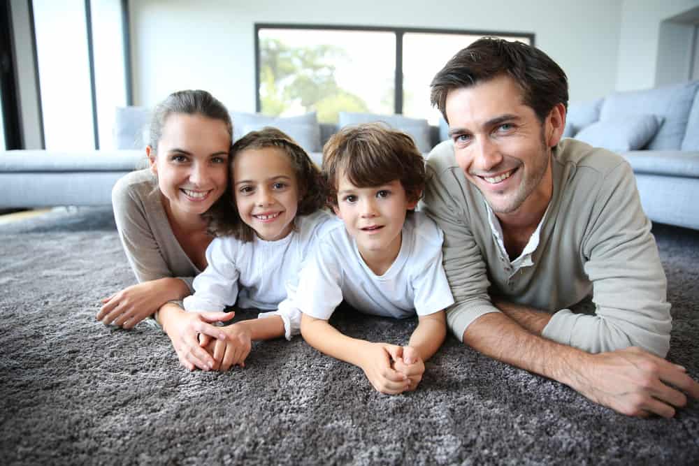 a family smiling and happy with their clean carpet